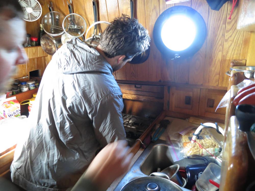 Jason Re works the galley plumbing, to maximize our fresh and salt water efficiency under way.